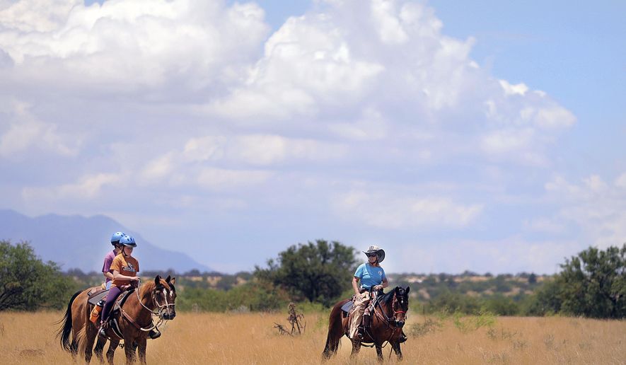 Horses are taken for a ride at Horse'n Around Rescue Ranch and Foundation in Hereford, Ariz., on Tuesday, June 28, 2022. With inflation hitting hay, bag feed and medications, the nonprofit ranch receives calls almost daily from desperate horse owners who are asking if Horse'n Around will take their equines. (Mark Levy/Sierra Vista Herald via AP)