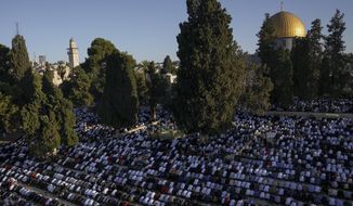 Muslim worshipers offer Eid al-Adha prayers next to the Dome of the Rock shrine at the Al Aqsa Mosque compound in Jerusalem&#39;s Old City, Saturday, July 9, 2022. The major Muslim holiday, at the end of the hajj pilgrimage to Mecca, is observed around the world by believers and commemorates prophet Abraham&#39;s pledge to sacrifice his son as an act of obedience to God. (AP Photo/Mahmoud Illean)