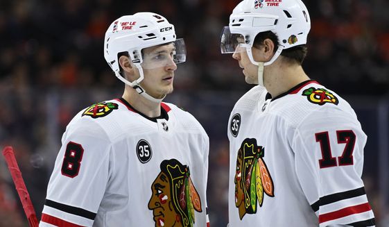 FILE - Chicago Blackhawks&#39; Dominik Kubalik, left, talks to Dylan Strome during an NHL hockey game against the Philadelphia Flyers, March 5, 2022, in Philadelphia. The Blackhawks continued to dismantle their roster by letting two more players walk. They declined to issue qualifying offers to forwards Kubalik and Strome. (AP Photo/Derik Hamilton, File)