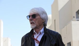 Former Formula One boss Bernie Ecclestone walks in the paddock during the first free practice at the Yas Marina racetrack in Abu Dhabi, United Arab Emirates, Friday, Nov. 23, 2018. British prosecutors say former Formula One boss Bernie Ecclestone will be charged with fraud by false representation following a government investigation into his overseas assets. (AP Photo/Kamran Jebreili, File)