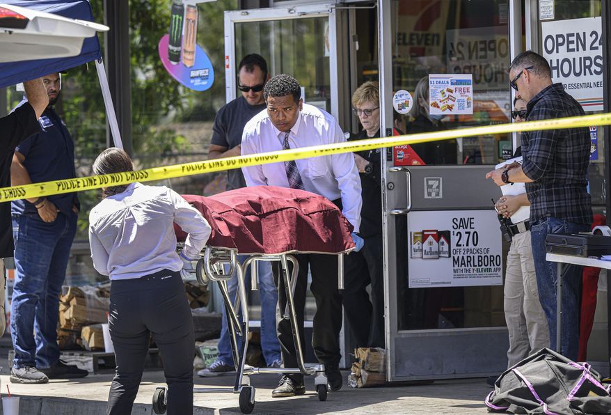 Authorities remove a body from a 7-Eleven after a clerk was fatally shot on Monday, July 11, 2022, during a robbery in Brea, Calif. (Mindy Schauer/The Orange County Register via AP)