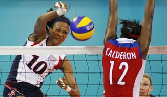 USA&#39;s Kim Glass, left, jumps for the ball with Cuba wing spiker Rosir Calderon during a women&#39;s Volleyball match at the Olympics in Beijing on Aug. 11, 2008. A former Olympic volleyball player was attacked Friday, July 8, 2022, in downtown Los Angeles when a man threw a metal object at her face in an assault that fractured bones in her face and left one of her eyes swollen shut, the athlete said in videos posted to social media. Glass, a silver medalist at the 2008 Beijing Olympics, had been leaving a lunch on Friday afternoon when she saw a man run up with something in his hand. (AP Photo/Luca Bruno, File)