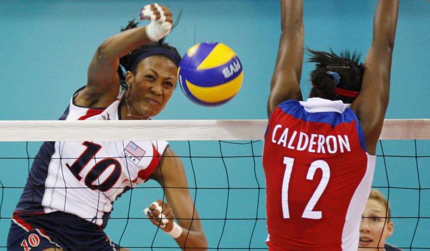 USA&#39;s Kim Glass, left, jumps for the ball with Cuba wing spiker Rosir Calderon during a women&#39;s Volleyball match at the Olympics in Beijing on Aug. 11, 2008. A former Olympic volleyball player was attacked Friday, July 8, 2022, in downtown Los Angeles when a man threw a metal object at her face in an assault that fractured bones in her face and left one of her eyes swollen shut, the athlete said in videos posted to social media. Glass, a silver medalist at the 2008 Beijing Olympics, had been leaving a lunch on Friday afternoon when she saw a man run up with something in his hand. (AP Photo/Luca Bruno, File)