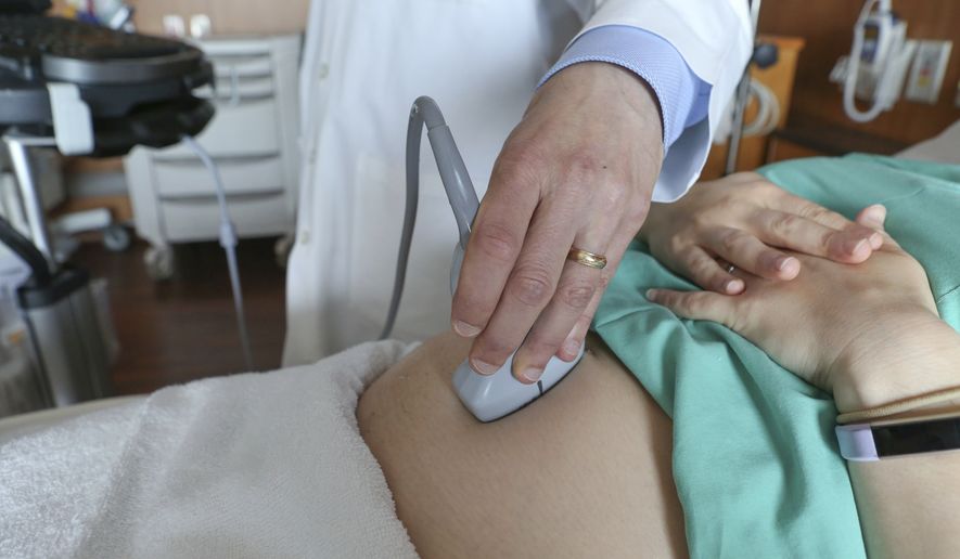 In this Aug. 7, 2018 photo, a doctor performs an ultrasound scan on a pregnant woman at a hospital in Chicago. The arrival of a new baby is all-consuming. You barely know what day it is, and mustering the energy and attention span for managing your financial household can be a tall order. Do your future, sleep-deprived self a favor and start preparing your finances early into your pregnancy. (AP Photo/Teresa Crawford, File)