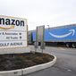 An Amazon Prime truck passes by a sign outside an Amazon fulfillment center on Staten Island, New York, on March 19, 2020. Amazon is heading into its annual Prime Day sales event on Tuesday, July 12, 2022, much differently than how it entered the pandemic. Once the darling of the pandemic economy, the company posted a rare quarterly loss in April as well as its slowest rate of revenue growth in nearly two decades at 7%. (AP Photo/Kathy Willens, File)