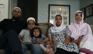 The Zakir family, from left, father Yusuf, son Burhanuddin, Yusuf&#x27;s niece, Insiya Maimoon; daughter Jumana, mother Fareeda, watch an episode of &amp;quot;Ms. Marvel&amp;quot; in Anaheim, Calif., Friday, July 8, 2022. Jumana knows who she is going to be for Halloween this year. Her new favorite superhero is a lot like her – female, teen, Muslim, American and “totally awesome.” (AP Photo/Jae C. Hong)