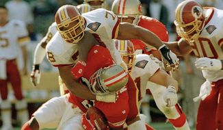 Defensive tackle Tim Johnson (78) of the Washington Redskins, wraps up running back Ricky Watters (32) of the San Francisco 49ers during their first quarter of play at RFK Stadium in Washington, D.C., Nov. 6, 1994. (AP Photo/Denis Paquin) **FILE**