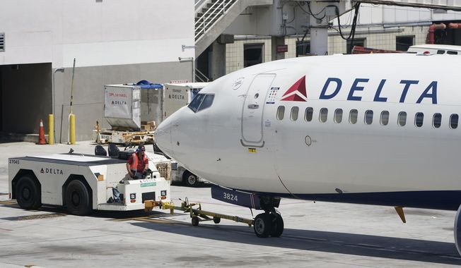 A tug driver pushes a Delta Air Lines Boeing 737 back from a gate, Thursday, July 7, 2022, at the Fort Lauderdale-Hollywood International Airport in Fort Lauderdale, Fla. Delta Air Lines said Wednesday, July 13, 2022, that it earned $735 million in the second quarter. Earnings per share fell short of Wall Street expectations, however, which the airline blamed on high fuel prices and more than 4,000 canceled flights in May and June. (AP Photo/Wilfredo Lee)