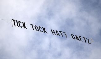A banner reading &amp;quot;Tick Tock Matt Gaetz&amp;quot; is flown above the federal courthouse during a hearing for Joel Greenberg, on May 17, 2021, in Orlando, Fla. Sentencing for a former Florida tax collector whose arrest led to a probe of U.S. Rep. Matt Gaetz has been set for December 2022, as his lawyer indicated that his client continues to cooperate with federal investigators in Florida, the District of Columbia and other jurisdictions. (AP Photo/Phelan M. Ebenhack, File)