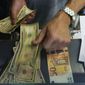 A cashier changes a 50 Euro banknote with US dollars at an exchange counter in Rome, Wednesday, July 13, 2022. The euro on Tuesday fell to parity with the dollar for the first time in nearly 20 years. (AP Photo/Gregorio Borgia)