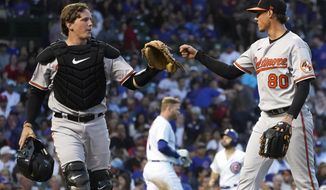 Baltimore Orioles catcher Adley Rutschman, left, acknowledges starting pitcher Spenser Watkins&#39; strikeout of Chicago Cubs&#39; Ian Happ, center, to end the third inning of a baseball game Wednesday, July 13, 2022, in Chicago. (AP Photo/Charles Rex Arbogast)