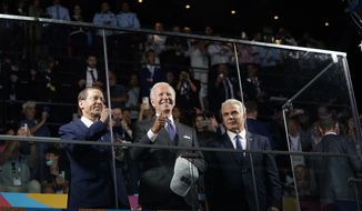 President Joe Biden gives a thumbs up as he stands behind a glass partition with Israeli President Isaac Herzog, left, and Israeli Prime Minister Yair Lapid during the opening ceremonies of the Maccabiah Games at Teddy Stadium, Thursday, July 14, 2022, in Jerusalem. (AP Photo/Evan Vucci)