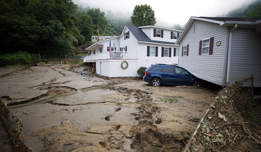 A house that was moved off of its foundation following a flash flood rests on top of a vehicle, Thursday, July 14, 2022, in Whitewood, Va. Virginia Gov. Glenn Youngkin declared a state of emergency to aid in the rescue and recovery efforts from Tuesday&#x27;s floodwaters. (AP Photo/Michael Clubb)