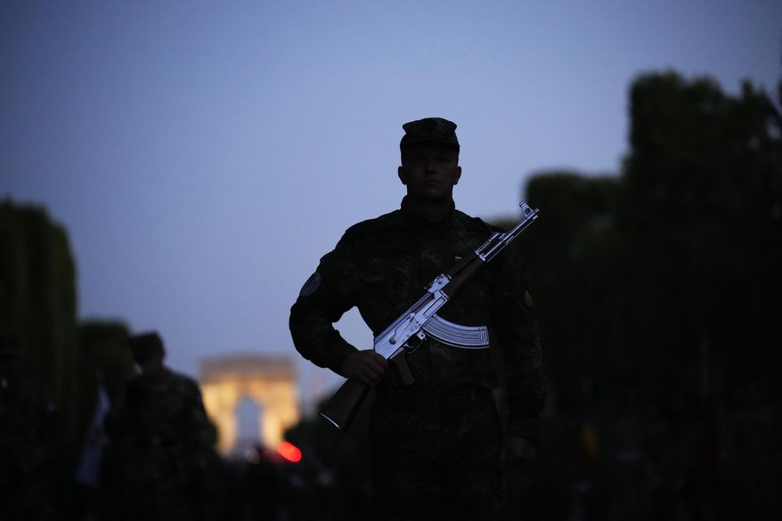 Soldiers of Bulgaria stand on the Champs Elysees avenue during a rehearsal for the Bastille Day parade in Paris, France, Monday, July 11, 2022. Paris is preparing for a big Bastille Day parade later this week, a military show on the Champs-Elysees avenue that this year will honor war-torn Ukraine and include troops from countries on NATO&#x27;s eastern flank: Poland, Hungary, Slovakia, Romania, Bulgaria, Czechia, Lithuania, Estonia and Latvia. (AP Photo/Christophe Ena)