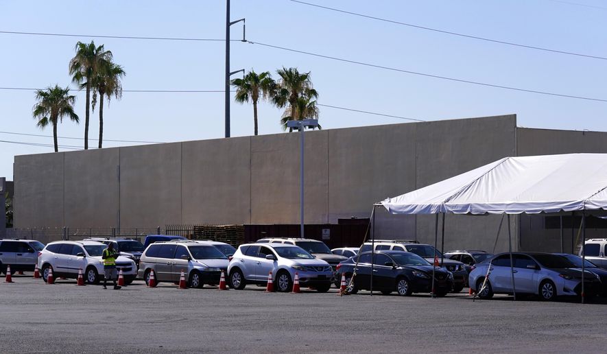 Dozens of vehicles line up to get food boxes at the St. Mary&#39;s Food Bank Wednesday, June 29, 2022, in Phoenix. Long lines are back at outside food banks around the U.S. as working Americans overwhelmed by inflation increasingly seek handouts to feed their families. Many people are coming for the first time amid the skyrocketing grocery and gas prices. (AP Photo/Ross D. Franklin)