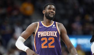 Phoenix Suns center Deandre Ayton looks on during the second half of an NBA basketball game on March 24, 2022, in Denver. The Indiana Pacers have signed restricted free agent Deandre Ayton to a four-year, $133 million offer sheet Thursday, July 14, 2022. Phoenix matched the offer to keep the center it selected with the top overall pick in the 2018 NBA draft. (AP Photo/David Zalubowski, File) **FILE**