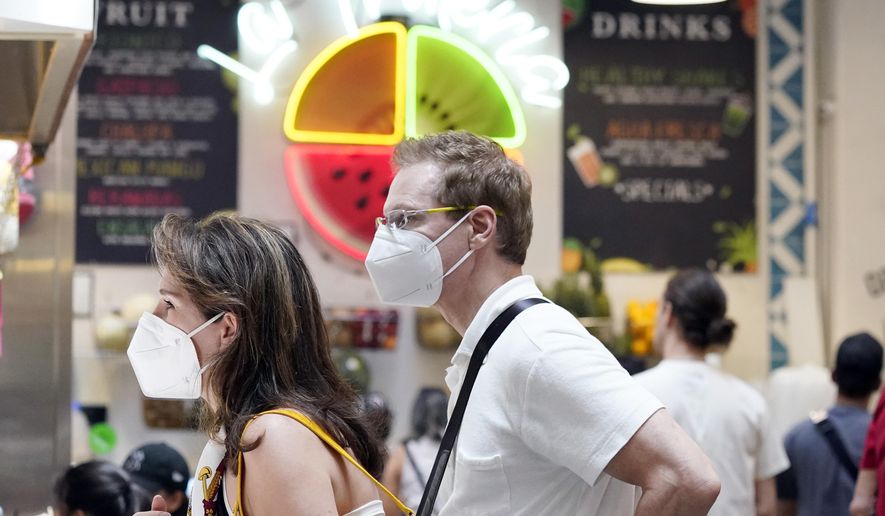 Masked patrons wait to order at a food stand inside Grand Central Market Wednesday, July 13, 2022, in Los Angeles. Los Angeles County might be imposing a mask-wearing mandate on July 29 if COVID-19 numbers continue to rise. (AP Photo/Marcio Jose Sanchez)