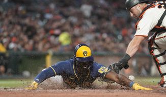 Milwaukee Brewers&#x27; Jonathan Davis scores next to San Francisco Giants catcher Joey Bart on a single by Willy Adames during the sixth inning of a baseball game in San Francisco, Thursday, July 14, 2022. (AP Photo/Godofredo A. Vásquez)