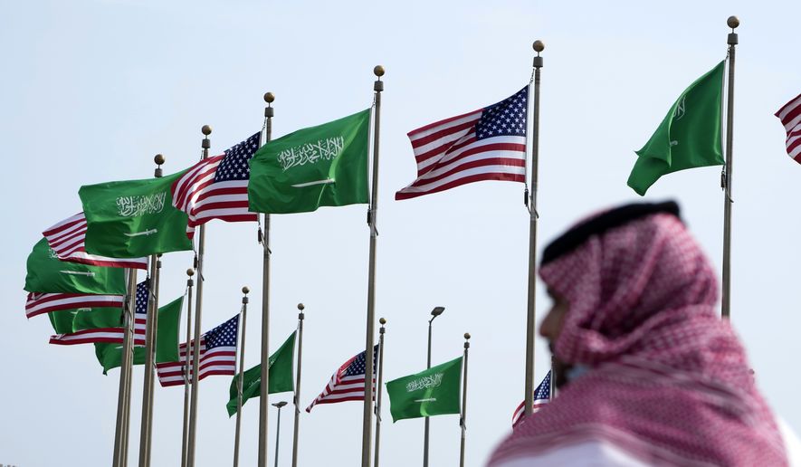 A man stands under American and Saudi Arabian flags prior to a visit by U. S. President Joe Biden, at a square in Jeddah, Saudi Arabia, Thursday, July 14, 2022. As President Joe Biden prepares to meet Saudi Crown Prince Mohammed bin Salman on Friday, the prince&#39;s reputation as a brazen leader whose rise to power coincided with a sweeping crackdown on critics will likely cast a shadow on the meeting. (AP Photo/Amr Nabil, File)