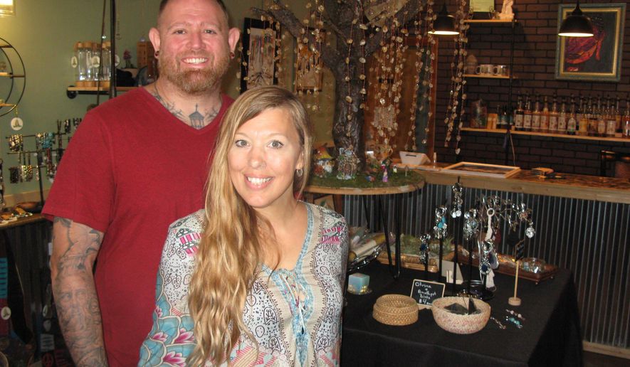 Chris Posey and Jessica Southall pose for a photo at the Gypsy Willow Metaphysical Cafe at 3009B Murdoch Ave., in Parkersburg, W.Va., on Thursday, June 30, 2022. Posey handles the coffee shop and Southall is in charge of metaphysical tools. The Parkersburg couple opened a spiritual healing boutique and coffee shop. (Jess Mancini/News and Sentinel via AP)