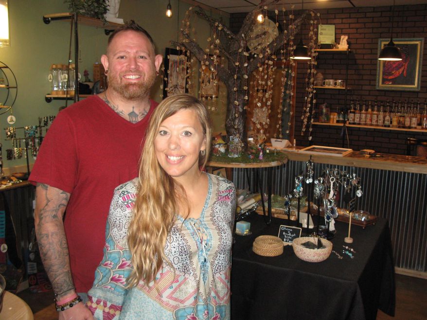 Chris Posey and Jessica Southall pose for a photo at the Gypsy Willow Metaphysical Cafe at 3009B Murdoch Ave., in Parkersburg, W.Va., on Thursday, June 30, 2022. Posey handles the coffee shop and Southall is in charge of metaphysical tools. The Parkersburg couple opened a spiritual healing boutique and coffee shop. (Jess Mancini/News and Sentinel via AP)