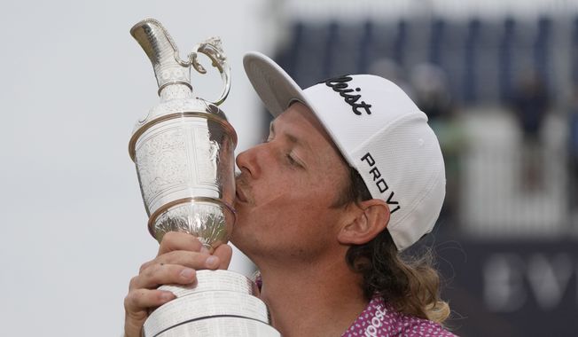 Cameron Smith, of Australia, kisses the claret jug trophy as he poses for photographers on the 18th green after winning the British Open golf Championship on the Old Course at St. Andrews, Scotland, Sunday July 17, 2022. (AP Photo/Gerald Herbert)