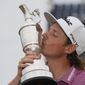 Cameron Smith, of Australia, kisses the claret jug trophy as he poses for photographers on the 18th green after winning the British Open golf Championship on the Old Course at St. Andrews, Scotland, Sunday July 17, 2022. (AP Photo/Gerald Herbert)