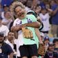 Actor Bryan Cranston is lifted by former Los Angeles Dodgers player Andre Ethier during the MLB All Star Celebrity Softball game, Saturday, July 16, 2022, in Los Angeles. (AP Photo/Mark J. Terrill)