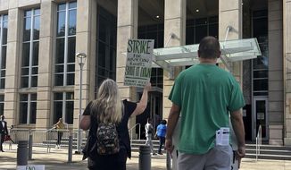 An abortion rights advocate demonstrates outside the 19th Judicial District Courthouse, Monday July 18, 2022, in Baton Rouge, La. (AP Photo/Stephen Smith)