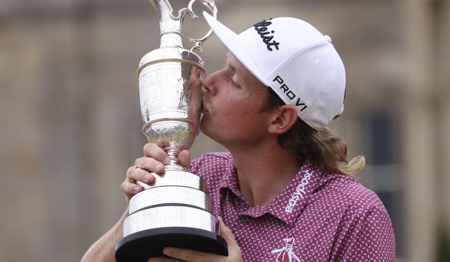 Cameron Smith, of Australia, kisses the claret jug trophy as he poses for photographers on the 18th green after winning the British Open golf Championship on the Old Course at St. Andrews, Scotland, Sunday July 17, 2022. (AP Photo/Peter Morrison)