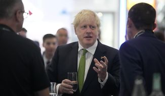 Britain&#39;s Prime Minister Boris Johnson, centre, speaks to CEOs as he attends the Farnborough International Airshow, in Farnborough, England, Monday, July 18, 2022. (AP Photo/Frank Augstein, Pool)