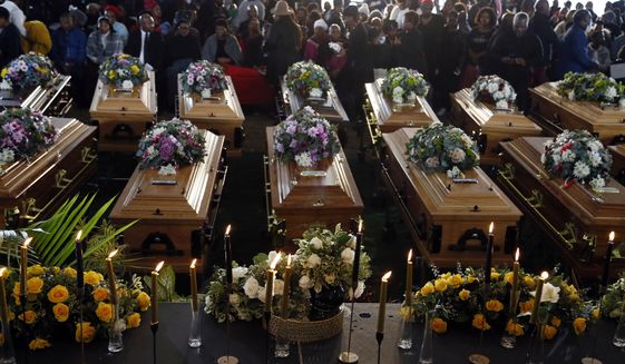 Coffins of 21 teenagers who died in a mysterious tragedy at a nightclub in the early hours of June 26, 2022 are lined up during their funeral held in Scenery Park, East London, South Africa, Wednesday, July 6, 2022. The toxic chemical methanol has been identified as a possible cause of the deaths of 21 teenagers at a bar in the South African city of East London last month, authorities said at press conference in East London Tuesday. July 19, 2022.  (AP Photo/File)
