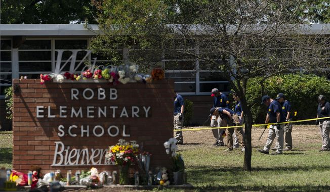 Investigators search for evidences outside Robb Elementary School in Uvalde, Texas, Wednesday, May 25, 2022. A gunman fatally shot 19 children and two teachers at the school the day before on May 24. (AP Photo/Jae C. Hong, File)