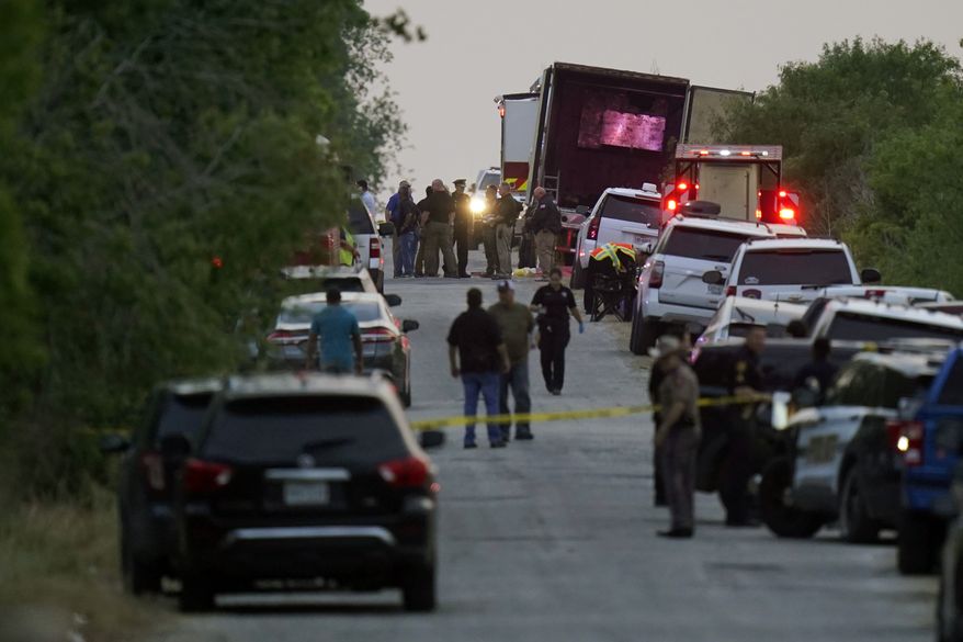 Police and other first responders work the scene where officials say dozens of people have been found dead and multiple others were taken to hospitals with heat-related illnesses after a tractor-trailer containing suspected migrants was found on June 27, 2022, in San Antonio. Officials said two men were indicted Wednesday, July 20 in the case.  (AP Photo/Eric Gay, File)