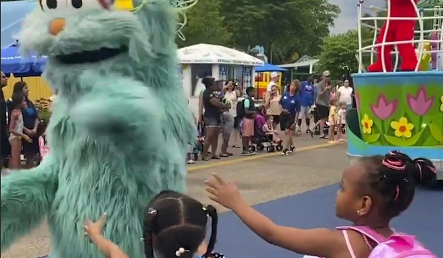 In this image from video provided by Jodi Brown, posted to Instagram on Saturday, July 16, 2022, a performer dressed as the character Rosita waves off Brown&#39;s daughter and another 6-year-old Black girl at the Sesame Place amusement park in Langhorne, Pa. (Jodi Brown via AP)