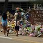 In this July 12, 2022, photo, Visitors walk past a makeshift memorial honoring those killed at Robb Elementary School, in Uvalde, Texas. Parents in Uvalde, Texas, are livid about the security lapses that contributed to the school shooting this spring. They&#39;re terrified to send their kids back to school. Yet further securing schools -- such as through additional lockdown drills -- is controversial. (AP Photo/Eric Gay, FILE)