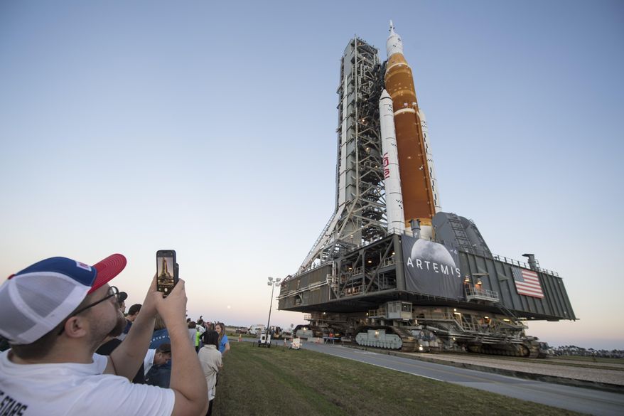 Invited guests and NASA employees take photos as NASA's Space Launch System (SLS) rocket with the Orion spacecraft aboard is rolled out of High Bay 3 of the Vehicle Assembly Building for the first time, at the Kennedy Space Center in Cape Canaveral, Fla., Thursday, March 17, 2022. On Wednesday, July 20, 2022, the 53rd anniversary of the Apollo 11 moon landing, NASA said it’s shooting for a late August test launch of its giant, new moon rocket. (Aubrey Gemignani/NASA via AP, File)