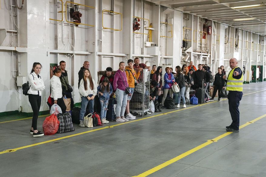 Ukrainian refugees line up as they arrive to get accommodations on the ferry Isabelle in Tallinn, Estonia, Wednesday, June 15, 2022. Around 2,000 refugees from Ukraine live on the ferry. (AP Photo)