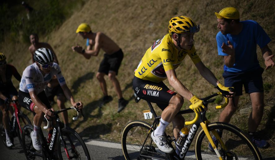 Denmark&#39;s Jonas Vingegaard, wearing the overall leader&#39;s yellow jersey, and Slovenia&#39;s Tadej Pogacar, wearing the best young rider&#39;s white jersey, climb towards Hautacam during the eighteenth stage of the Tour de France cycling race over 143.5 kilometers (89.2 miles) with start in Lourdes and finish in Hautacam, France, Thursday, July 21, 2022. (AP Photo/Daniel Cole)