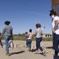 A group of Brazilian migrants make their way around a gap in the U.S.-Mexico border in Yuma, Ariz., seeking asylum in the U.S. after crossing over from Mexico, June 8, 2021. Two Republican border-state governors who are investing billions of dollars on immigration enforcement and hours at the podium blasting the Biden administration policies have found two unlikely allies: Democratic mayors Muriel Bowser of Washington, D.C., and Eric Adams of New York. The mayors&#39; recent overtures for federal aid is a response to Texas and Arizona busing migrants away from the border, a months-old practice that has been long on political theater and short on practical impact. (AP Photo/Eugene Garcia, File)
