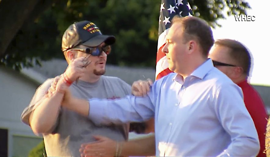In this image taken from video provided by WHEC-TV, David Jakubonis, left, brandishes a sharp object as he attacks U.S. Rep. Lee Zeldin, right, as the Republican candidate for New York governor delivered a speech in Perinton, N.Y., Thursday, July 21, 2022. Jakubonis, 43, has been charged with attempted assault, arraigned and released, a Monroe County sheriff&#39;s spokesperson said. (WHEC-TV via AP)