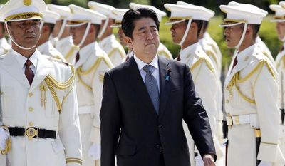 Then Japanese Prime Minister Shinzo Abe, center, reviews an honor guard in a ceremony prior to his meeting with high-ranked officers of the Japan Self-Defense Forces at the Defense Ministry in Tokyo on Sept. 12, 2013. Former Japanese Prime Minister Abe, a divisive arch-conservative and one of his nation&#39;s most powerful and influential figures, has died after being shot during a campaign speech Friday, July 8, 2022, in western Japan, hospital officials said.(AP Photo/Koji Sasahara, File)