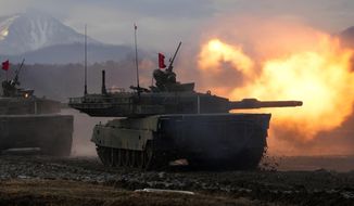 Japanese Ground-Self Defense Force (JGDDF) Type 90 tank fires its gun at a target during an annual drill exercise at the Minami Eniwa Camp in Eniwa, Japan&#39;s northern island of Hokkaido on Dec. 7, 2021. Japan warned of escalating national security threats stemming from Russia’s war on Ukraine and China’s tensions with Taiwan in an annual defense paper issued Friday, July 22, 2022, as Japan tries to bolster its military capability and spending. (AP Photo/Eugene Hoshiko) **FILE**
