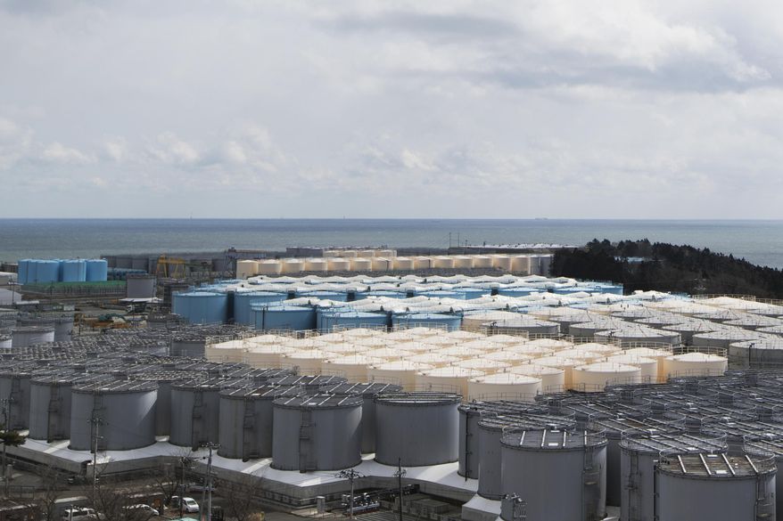 FILE - This photo shows tanks (in gray, beige and blue) storeing water that was treated but is still radioactive after it was used to cool down spent fuel at the Fukushima Daiichi nuclear power plant in Okuma town, Fukushima prefecture, northeastern Japan, on Feb. 27, 2021. Japan’s nuclear regulator on Friday, July 22, 2022, approved the release of treated radioactive wastewater from the wrecked Fukushima nuclear power plant into the sea next year. (AP Photo/Hiro Komae, File)