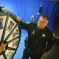 In this July 2017 photo, Brevard County Sheriff Wayne Ivey gets ready to spin his popular &quot;Wheel of Fugitive&quot; in Titusville, Fla. The popular videos feature photos of 10 of the county&#39;s most wanted criminals. (Malcolm Denemark/Florida Today via AP)