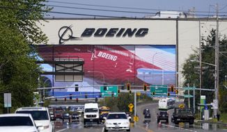 Traffic drives in view of a Boeing Co. production plant, where images of jets decorate the hangar doors on April 23, 2021, in Everett, Wash. Roughly 2,500 Boeing workers are expected to go on strike the following month at three plants in the St. Louis area after they voted Sunday, July 24, 2022, to reject a contract offer from the plane maker. (AP Photo/Elaine Thompson, File)