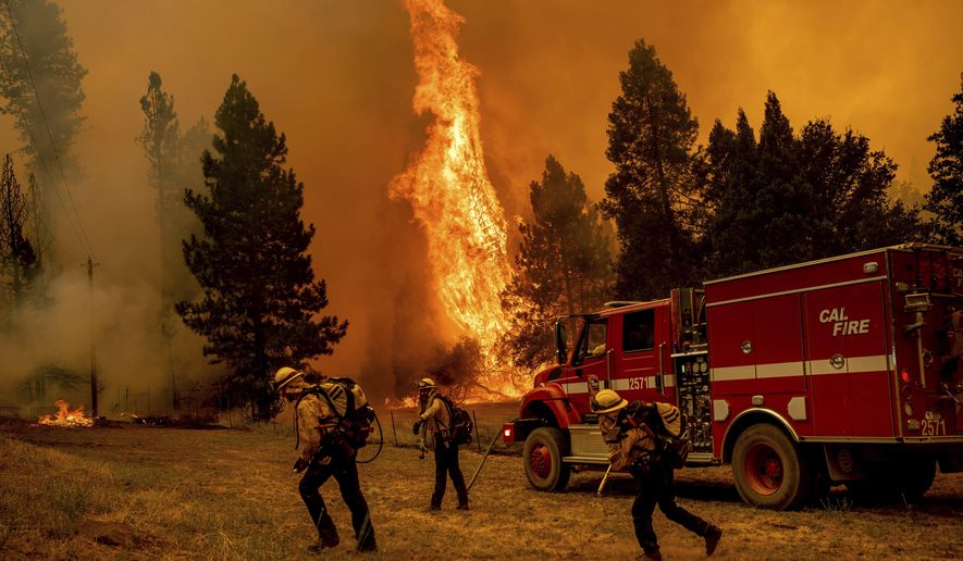 Firefighters work to keep the Oak Fire from reaching a home in the Jerseydale community of Mariposa County, Calif., on Saturday, July 23, 2022. (AP Photo/Noah Berger)