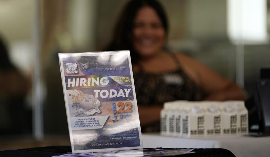 A hiring sign is placed at a booth for prospective employers during a job fair Wednesday, Sept. 22, 2021, in the West Hollywood section of Los Angeles. According to a new study released Monday, July 25, 2022, by the U.S. Census Bureau, by age 26 more than two-thirds of millennials lived in the same general area where they grew up, 80% had moved less than 100 miles away and 90% resided less than 500 miles away. (AP Photo/Marcio Jose Sanchez, File)