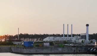 The sun rises behind the landfall facility of the Nord Stream 1 Baltic Sea pipeline and the transfer station of the OPAL gas pipeline, the Baltic Sea Pipeline Link, in Lubmin, Germany, Thursday, July 21, 2022. The operator of the major pipeline from Russia to Europe says natural gas has started flowing again after a 10-day shutdown for maintenance. (AP Photo/Markus Schreiber)