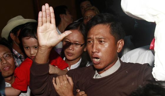 Kyaw Min Yu, a pro-democracy activist talks to journalists as he arrives at Yangon airport welcomed by his wife Nilar Thein, background, also an activist and his daughter after being released from a prison on Jan. 13, 2012, in Yangon. Myanmar has carried out its first executions in nearly 50 years. Kyaw Min Yu, a 53-year-old democracy activist better known as Ko Jimmy, was executed for violating the counterterrorism law. (AP Photo/File)